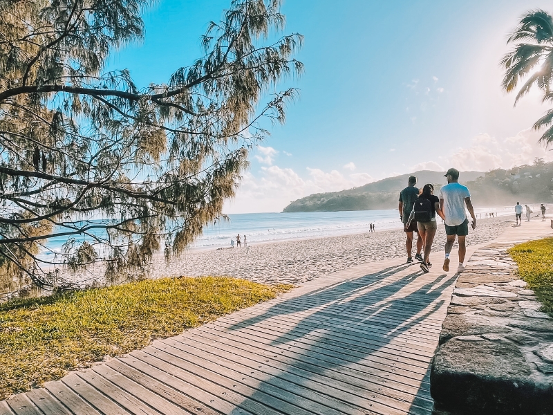 people walking along noosa main beach boardwalk